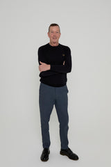Jay Pollard - Executive director of ATIA ACTIVE wearing a black sweater and gray pants standing against a white background
