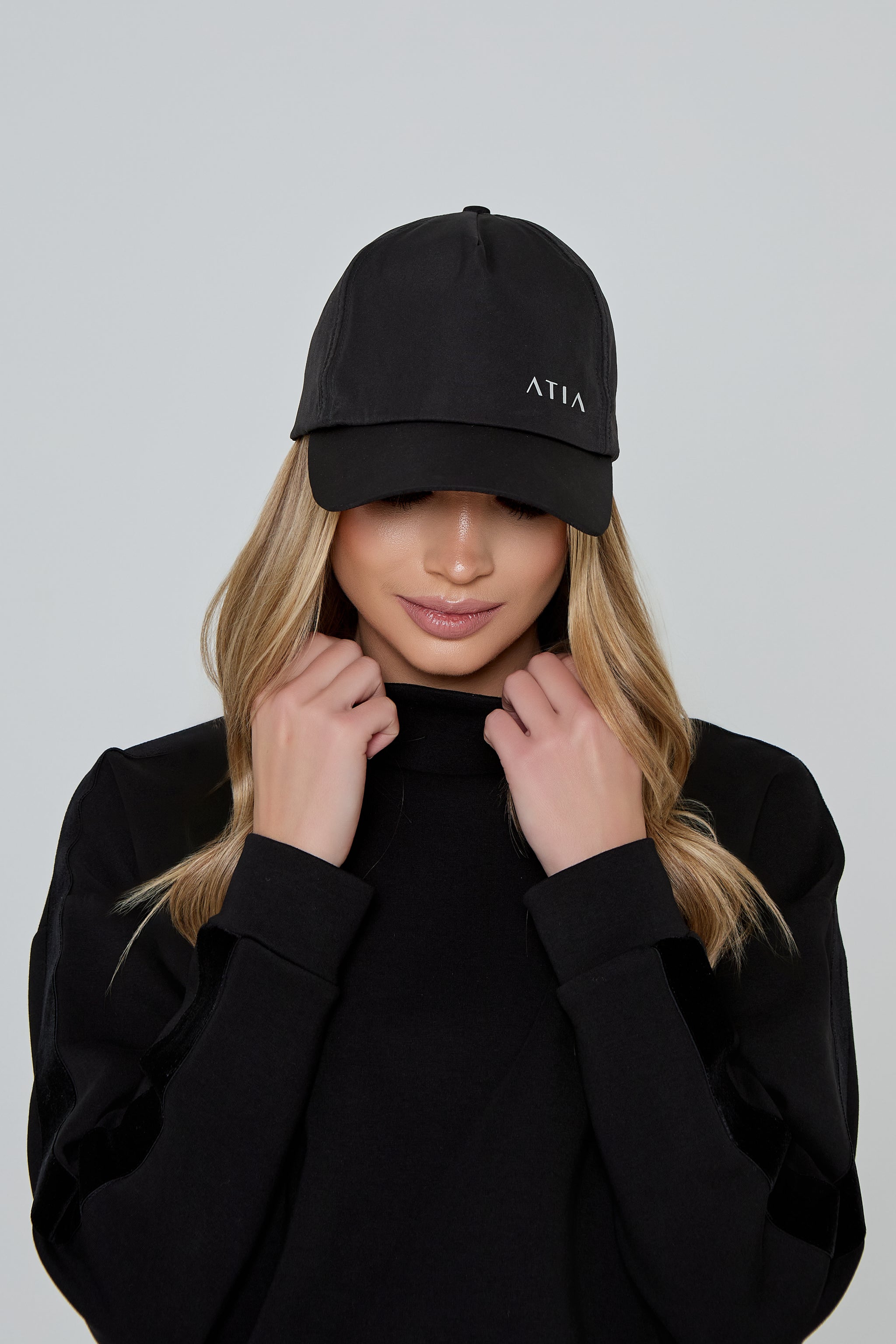 Model wears AGILITY SPORTS CAP in black with silver branding