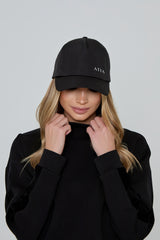 Model wears AGILITY SPORTS CAP in black with silver branding