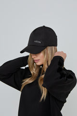 Model wears AGILITY SPORTS CAP in black with silver branding