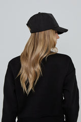 Model wears AGILITY SPORTS CAP in black with silver branding