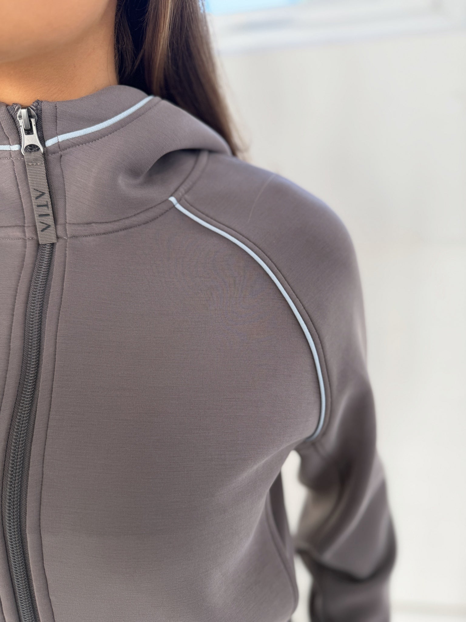VELA Hood Jacket in Truffle, close-up detail of cropped zip hoodie worn with white contrast trim, front view