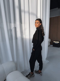 Impact Joggers in Black, worn with black cuffed sweatpants and sneakers, styled on model