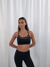 ENERGISE SPORTS BRA in BLACK, worn, shown from front with halter neckline and criss-cross back detail