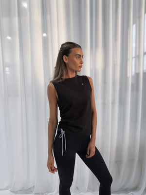 Challenger Tank in Black with side tie detail, worn by model against white curtain backdrop