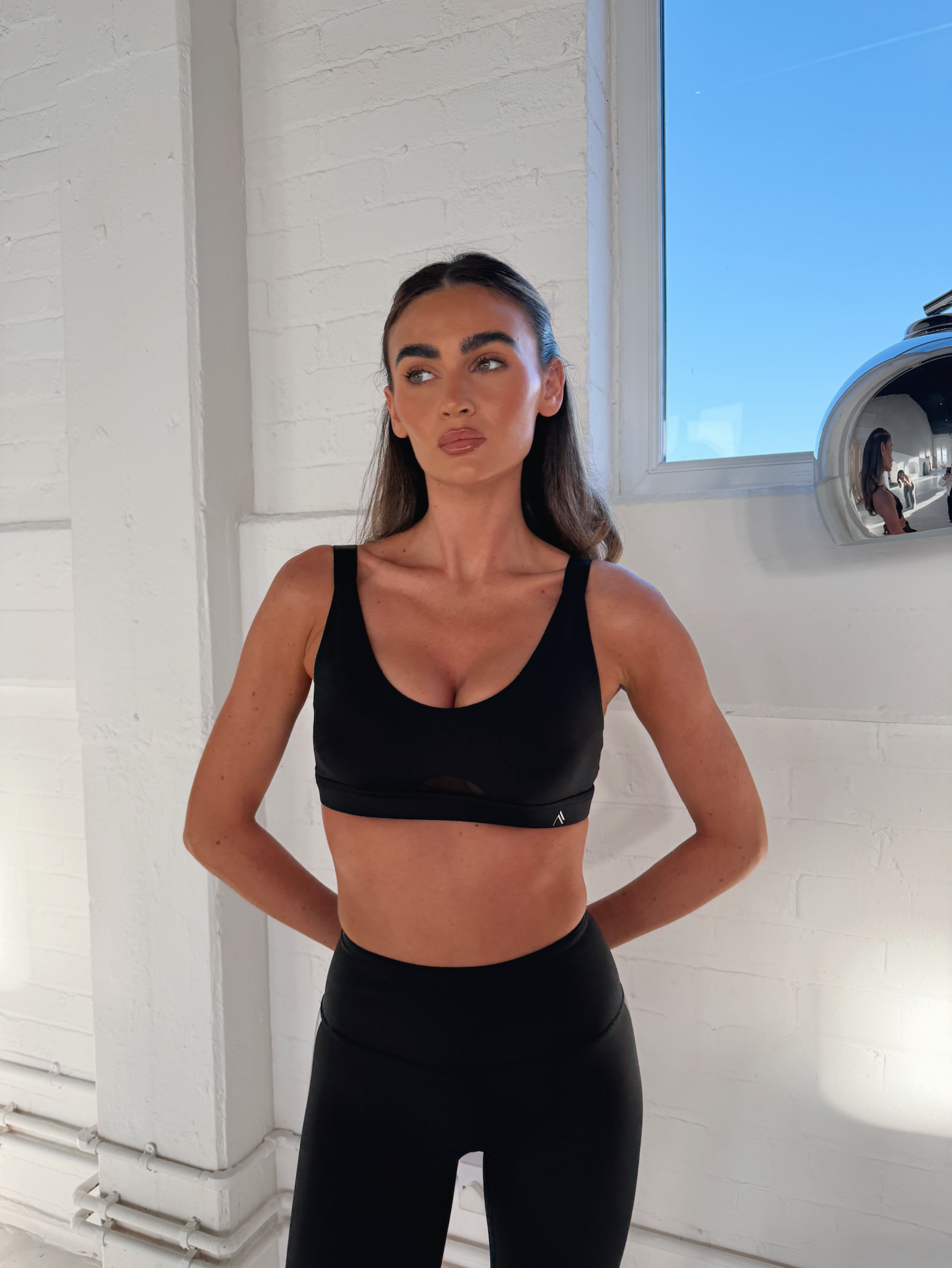 FORTIFY SPORTS BRA in BLACK, worn by model, front view showing scoop neckline and moisture-wicking fabric